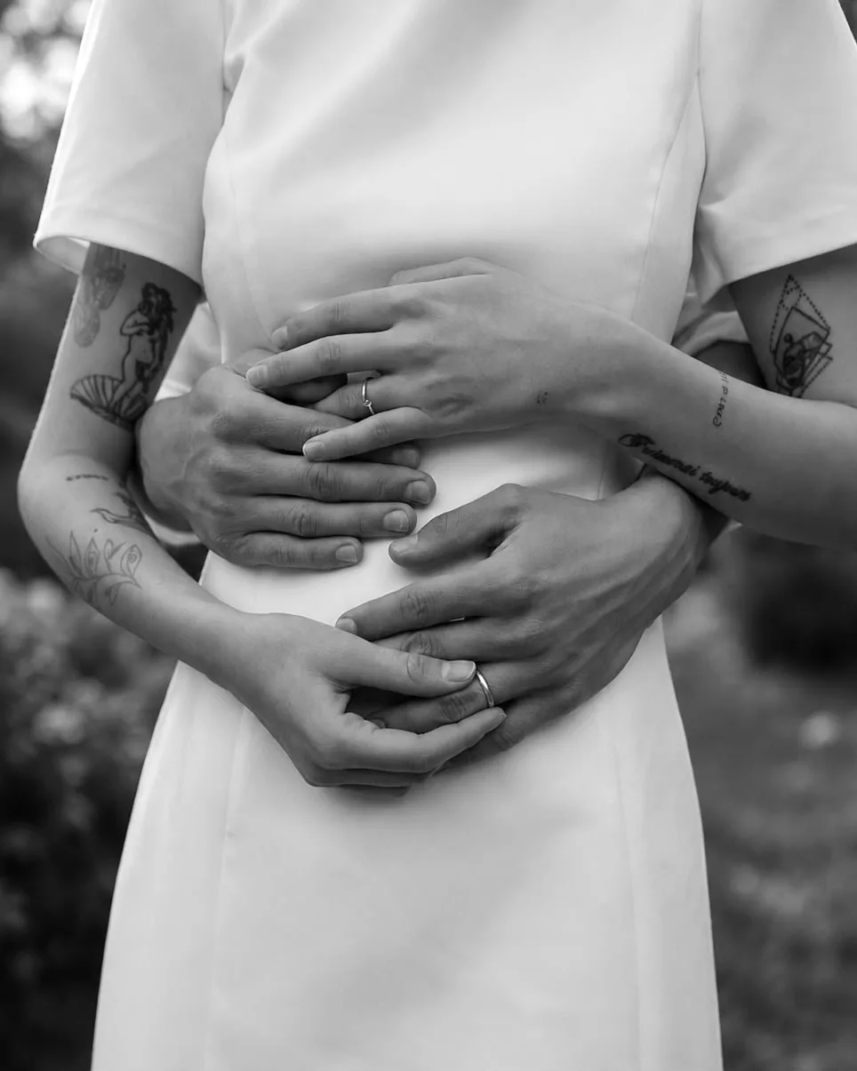 Las manos de Agustina y Leonel en un abrazo, con sus anillos y tatuajes